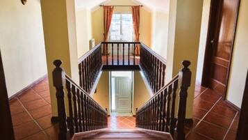 Eine Treppe mit einem Holzgeländer und Blick auf eine Tür am Fuß.