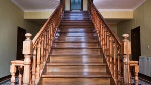 Eine Holztreppe mit Handlauf, die zu einer Tür führt.