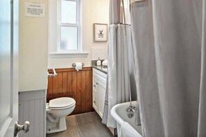 Een badkamer met toilet, wastafel en bad.