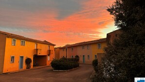 Un cortile con edifici, un percorso lastricato e cielo sereno.