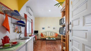 A kitchen with a dining area, a TV, and a sofa. - Portón 1 Studio – Renovated with Sea Views (Conil de la Frontera)