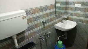 Un baño con inodoro, lavamanos y espejo.