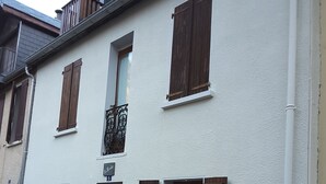 Eine Reihe weißer Gebäude mit Holzhörnern und Steinverzierungen am Sockel.