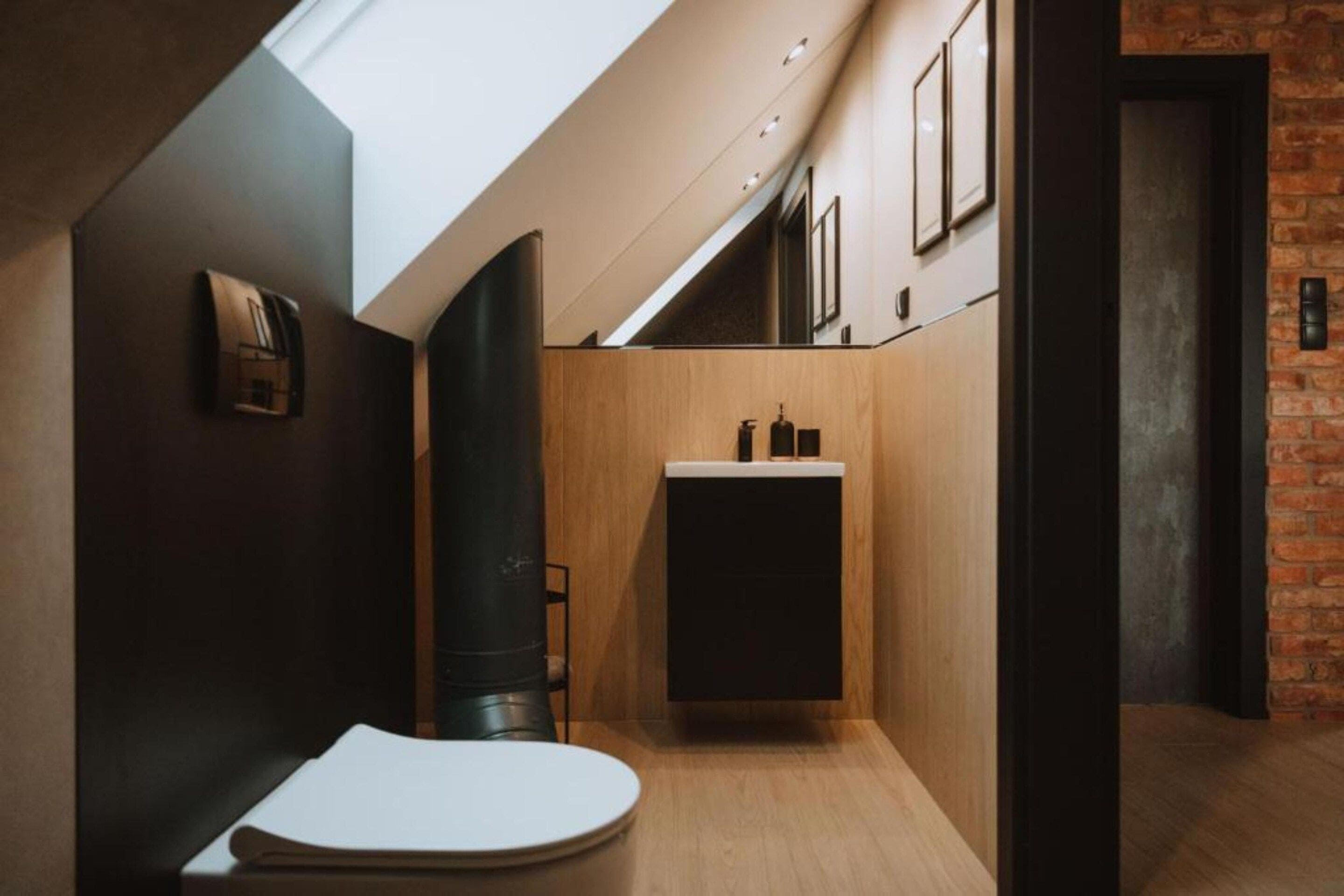 Ein modernes Badezimmer mit Oberlicht, Holzwaschtisch und Toilette.