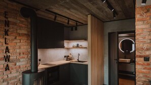 Cozinha com parede de tijolos, fogão e pia.