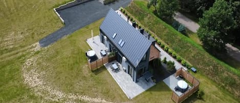 Une maison moderne avec un toit plat, une allée pavée et une pelouse bien entretenue.