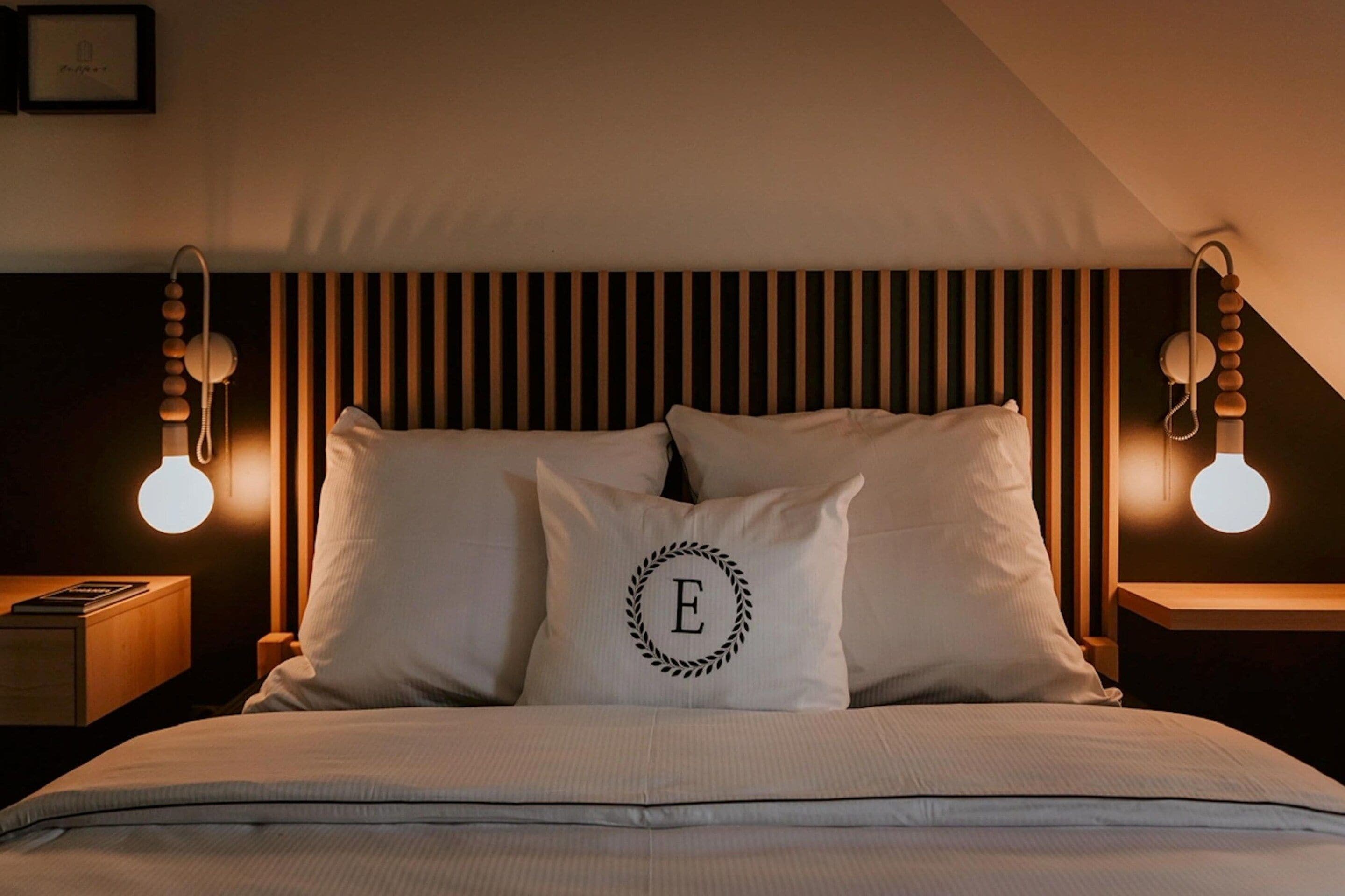 Una camera da letto con un letto, due comodini e un fiorile a parete.