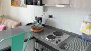A compact kitchen with a microwave, stove, and a small oven. - River view Downtown apartment 12th floor (Valdivia)