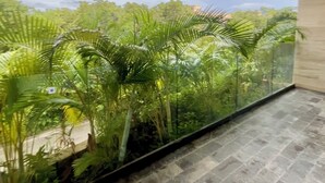 Un balcón con vistas a vegetación exuberante y un cielo nublado.