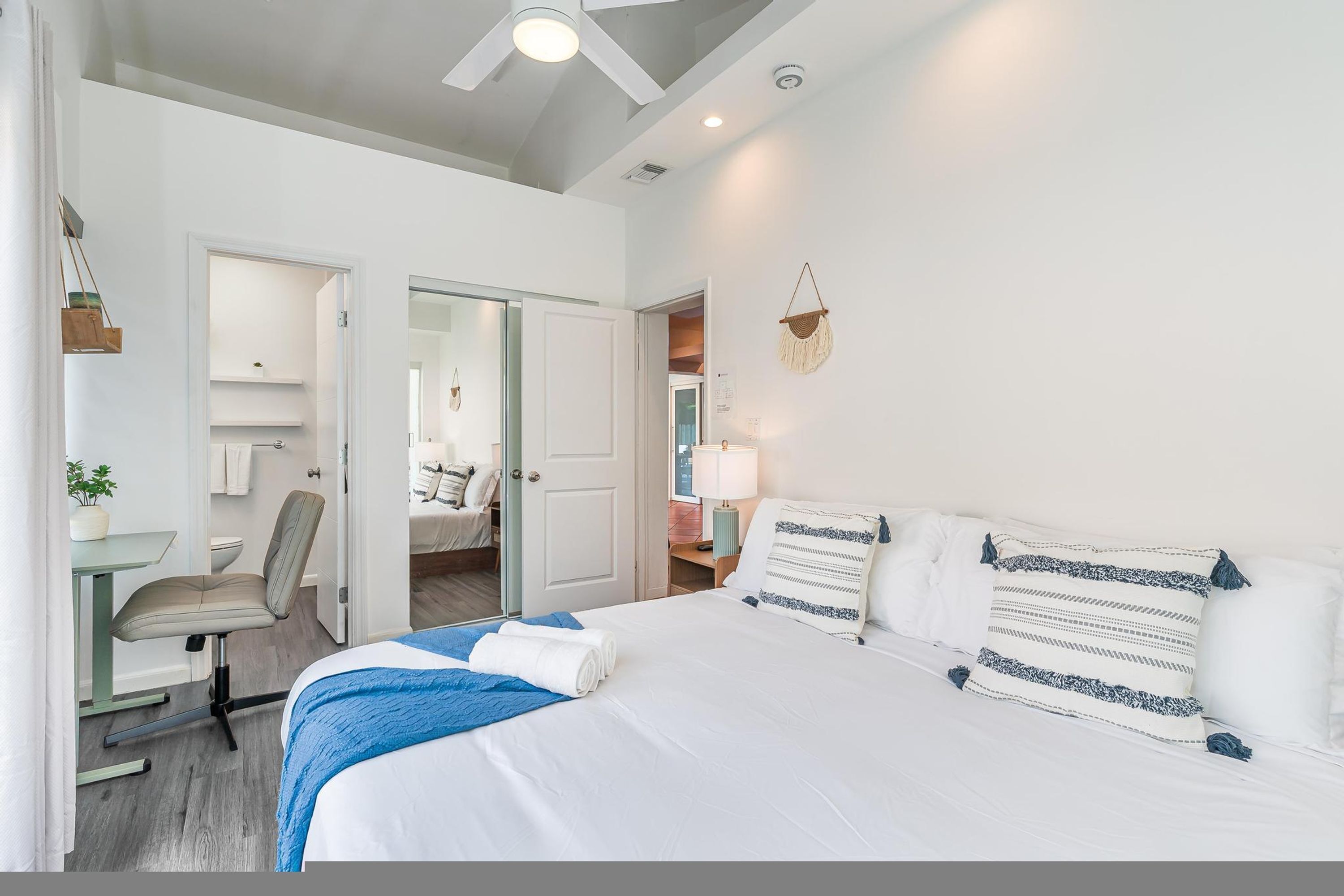 Une chambre d’hôtel comprenant un lit, un bureau, une chaise et une porte donnant sur une autre pi èce.