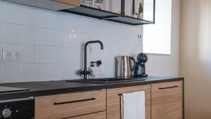 A modern kitchen with wooden cabinets, a black countertop, a built-in wine rack, and a window. - Luxury house in historic center Tomar with large and sunny private courtyard (Tomar)