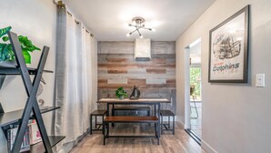 A dining area with a wooden wall, a ceiling fan, and a framed Miami Dolphins football helmet. - The Reef in Fort Lauderdale (Fort Lauderdale)