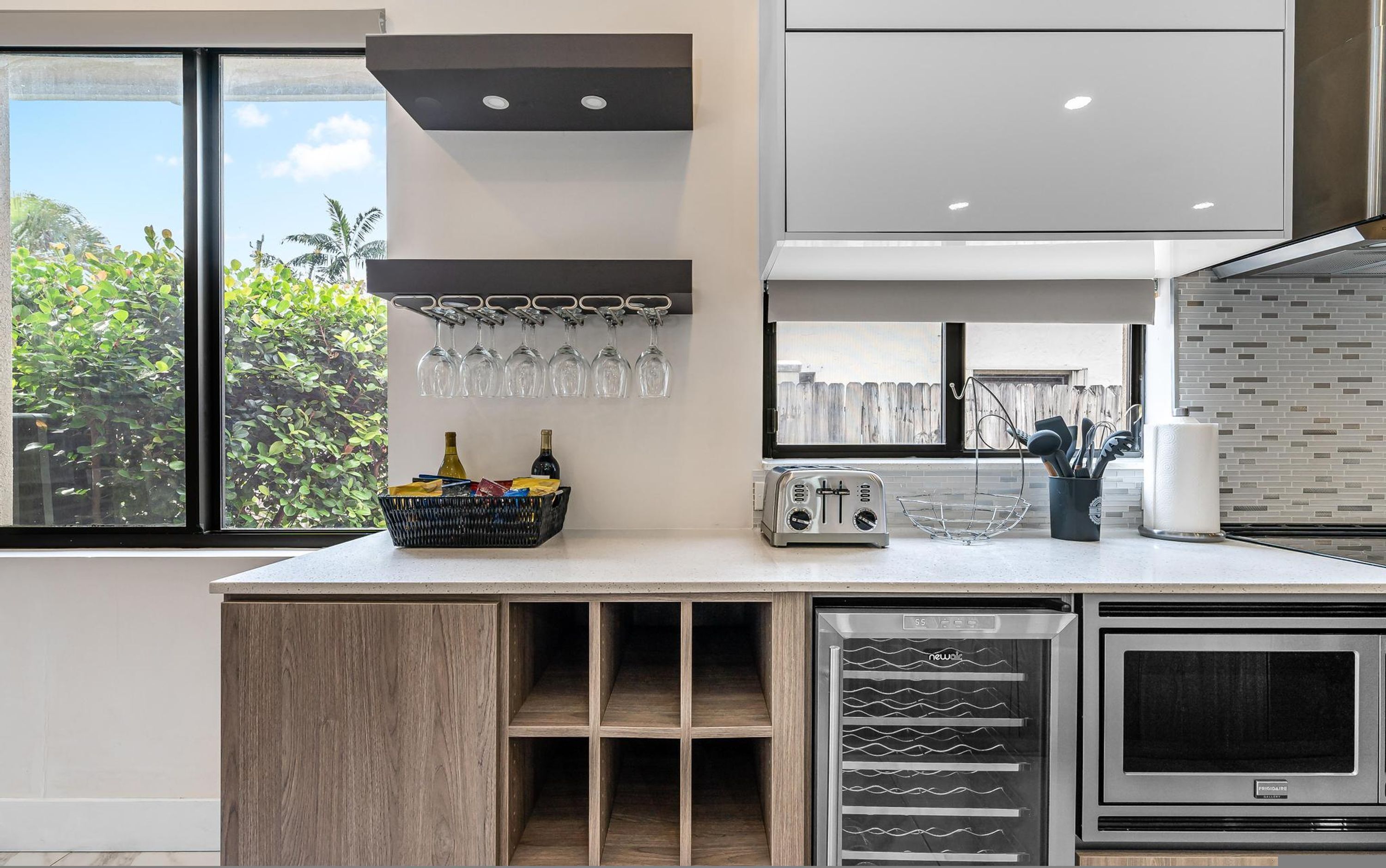 A modern kitchen with a built-in wine rack, a toaster, and a refrigerator.