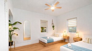 A hotel room with two beds, a ceiling fan, bedside lamps, a mirror, and a potted plant. - Fox Of Oz- Pool Spa Oasis Villa (Fort Lauderdale)