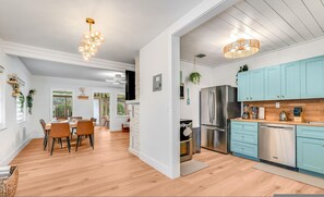 A modern kitchen with light blue cabinets, stainless steel appliances, and a wooden floor. - Fox Of Oz- Pool Spa Oasis Villa (Fort Lauderdale)