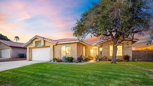A two-story house with a red-tiled roof, a front garage, and a well-maintained lawn. - Private Pool & Spa | Walk to Tennis Garden (La Quinta)