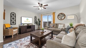 Ein Wohnzimmer mit Fernseher, Sofa, Couchtisch und Dekoration.