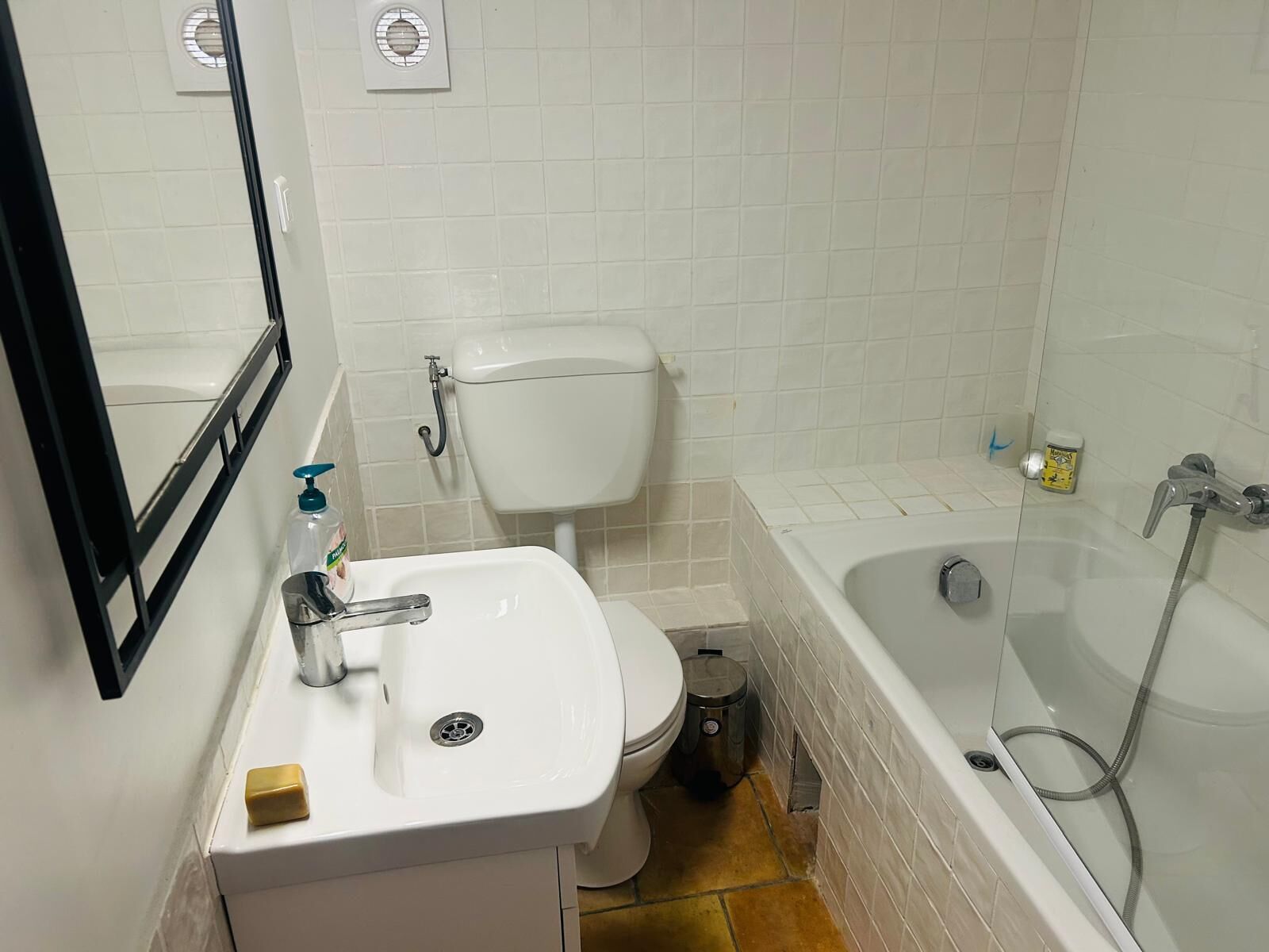Un bagno con lavandino, water e vasca da bagno bianchi.