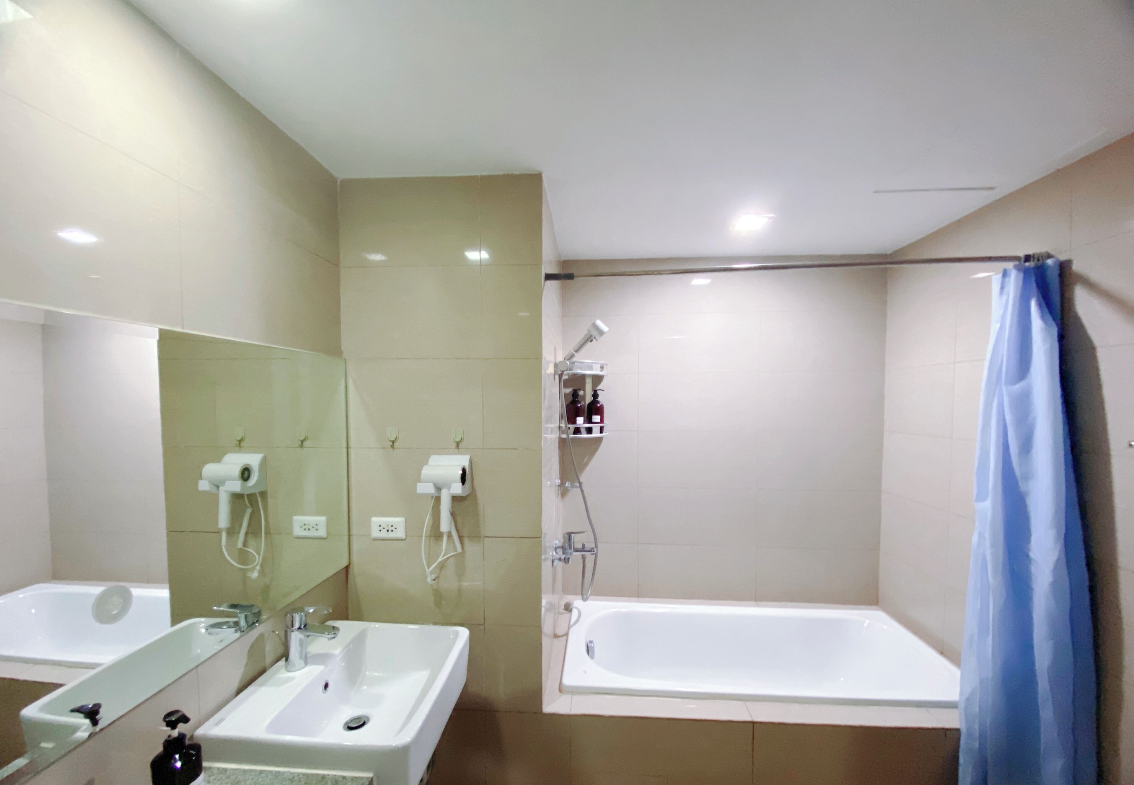Un baño con dos lavamanos, una bañera, una ducha y un espejo.