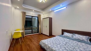 Une chambre à coucher comprenant un lit, une chaise, une armoire et un balcon avec des rideaux.