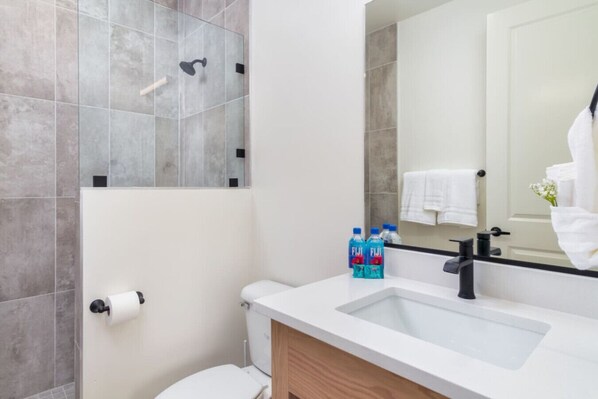 A modern bathroom with a shower, toilet, and sink. - Sleeps 26, Hot Tub, Outdoor Lounge Area, Near Zion (Hurricane)