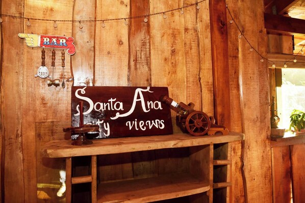 A wooden wall with a sign reading 'Santa Ana Views' and a 'BAR' sign above it. - Santa Ana City Views Chalet (Piedades)