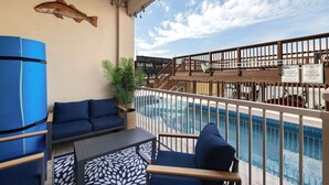 Un balcón con piscina, mobiliario azul y una decoración con motivos de peces.