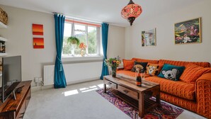 Ein Wohnzimmer mit Sofa, Couchtisch und Fernseher.