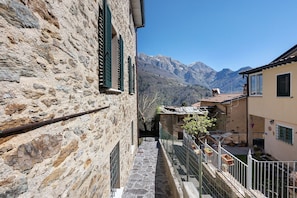 Un étroit sentier de pierre mène à un bâtiment dont l’arrière-plan est constitué d’une montagne.