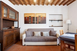 Un salon avec un canapé, un meuble en bois et des œuvres d’art accrochées au mur.