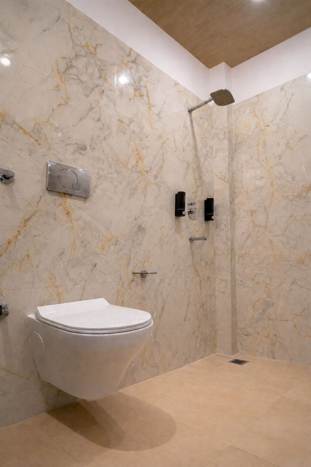 Une salle de bain avec un mur en marbre, des toilettes, une douche avec un pommeau de douche amovible et un porte-serviettes.