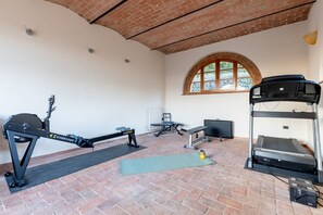 A gym with exercise equipment, a yoga mat, and a kettlebell. - GuestHost - Charming apartment located inside an old renovated barn in an agricultural estate on the Tuscan hills, surrounded by nature and with a breathtaking view of the surrounding countryside. The property, equipped with private outdoor parking, outd (Palaia)