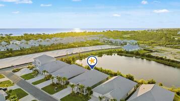 A residential area with houses, a body of water, and a clear sky.