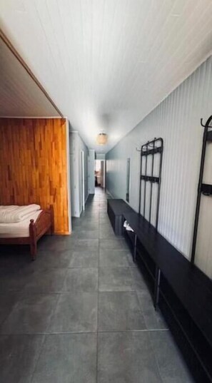 A hallway with a bed, bench, and a wall-mounted rack. - Large apartment with magnificent view 100 m from the slopes (Orcières)