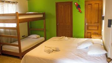 A room with bunk beds, a green wall, two wooden doors, and a parrot decoration.
