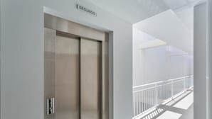 Un ascensor moderno con detalles metálicos y un letrero que indica 'SEGUNDO'.