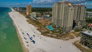Ein Hotel an der Küste mit Blick auf den Strand, mehreren Stockwerken und einem Schwimmbad.