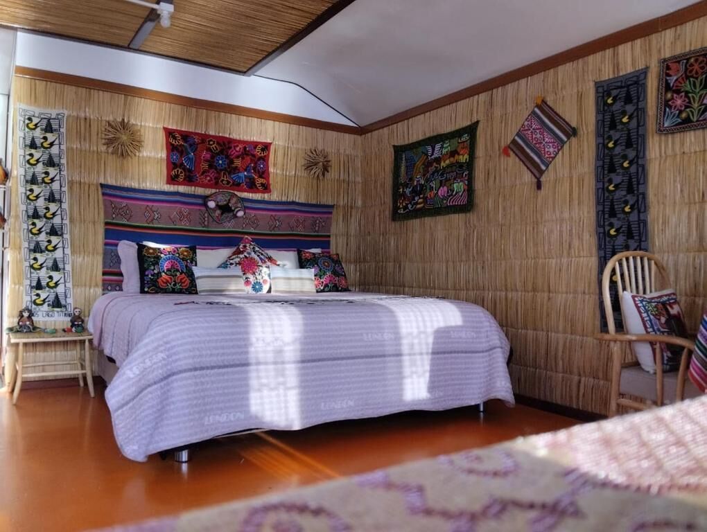 Una camera da letto con un letto, una sedia e decorazioni alle pareti.