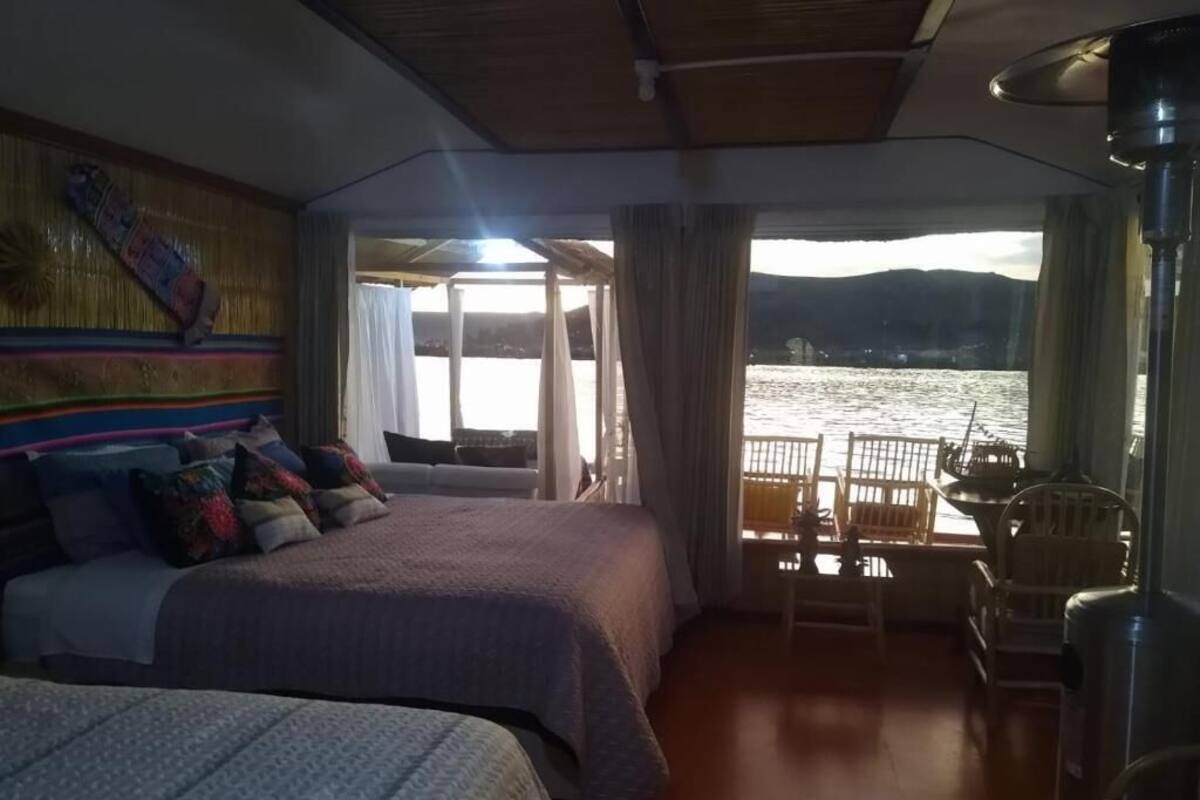Una habitación con cama, una silla y vistas a un cuerpo de agua.