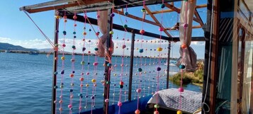 Una habitación con vista al agua, una cama y un adorno colgante.