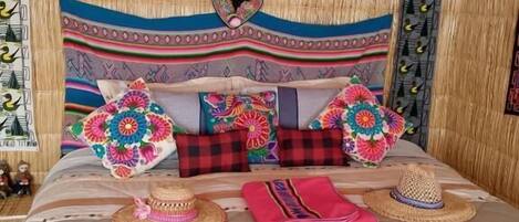 A bed with colorful floral bedding, a woven headboard, and decorative pillows.