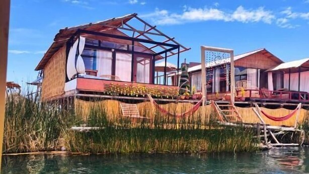 A bungalow with a large window, a pool, and a hammock. - Uros TITIKAKA the Best lodge  (Puno)