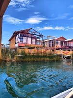 Una cabaña con un ventanal grande, una piscina y una hamaca.