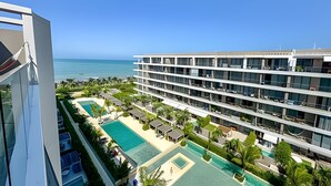 Een modern hotel met meerdere verdiepingen, een zwembad op het dak en uitzicht op de oceaan.