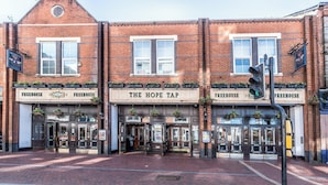 A brick building with multiple storefronts, including 'The Hope Tap.' - Brand New Flat with AC 5-Min Walk to Town Centre - Pass the Keys (Reading)