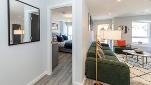 A modern living room with a green sofa, a floor lamp, and a dining table. - Brand New Flat with AC 5-Min Walk to Town Centre - Pass the Keys (Reading)