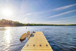 Une jetée en bois s’étendant sur une étendue d’eau calme, sous un ciel dégagé.