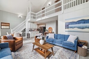 A spacious living area with a staircase, a dining area, and a kitchen. - Chalet w/ Hot Tub · Lake Beach · Resort Pools (Clifton Township)