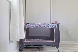 Un petit trampoline pour enfants orné d’un motif floral, un rideau blanc et un mur uni.