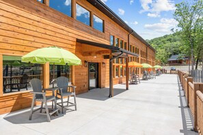 Un bâtiment en bois doté d’une terrasse et de parasols.